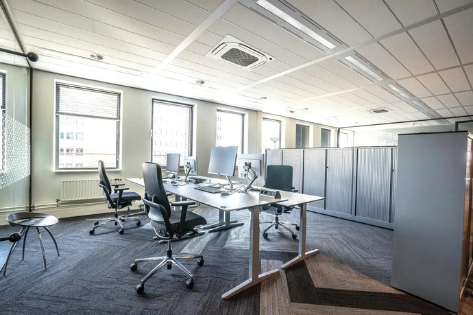 White office cubicle partition with gray panels and black mesh chairs.