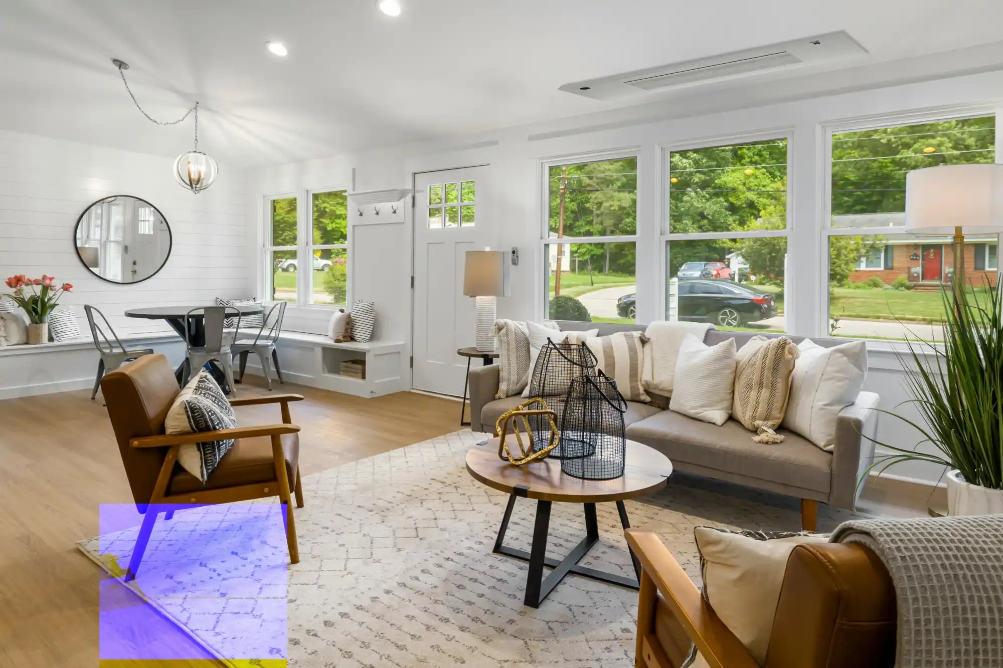 White modern sofa with wooden legs and striped cushions.
