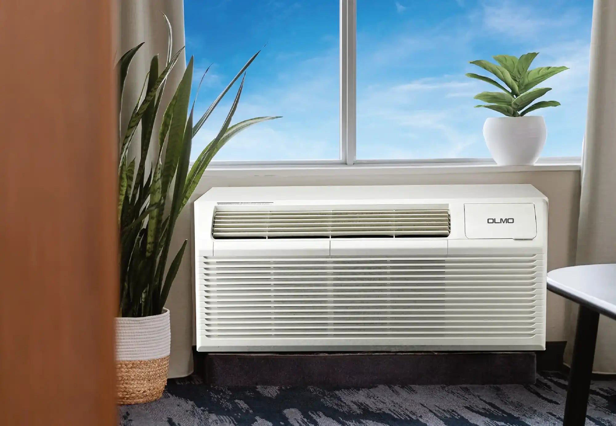 White window air conditioner with grille design and brand logo.